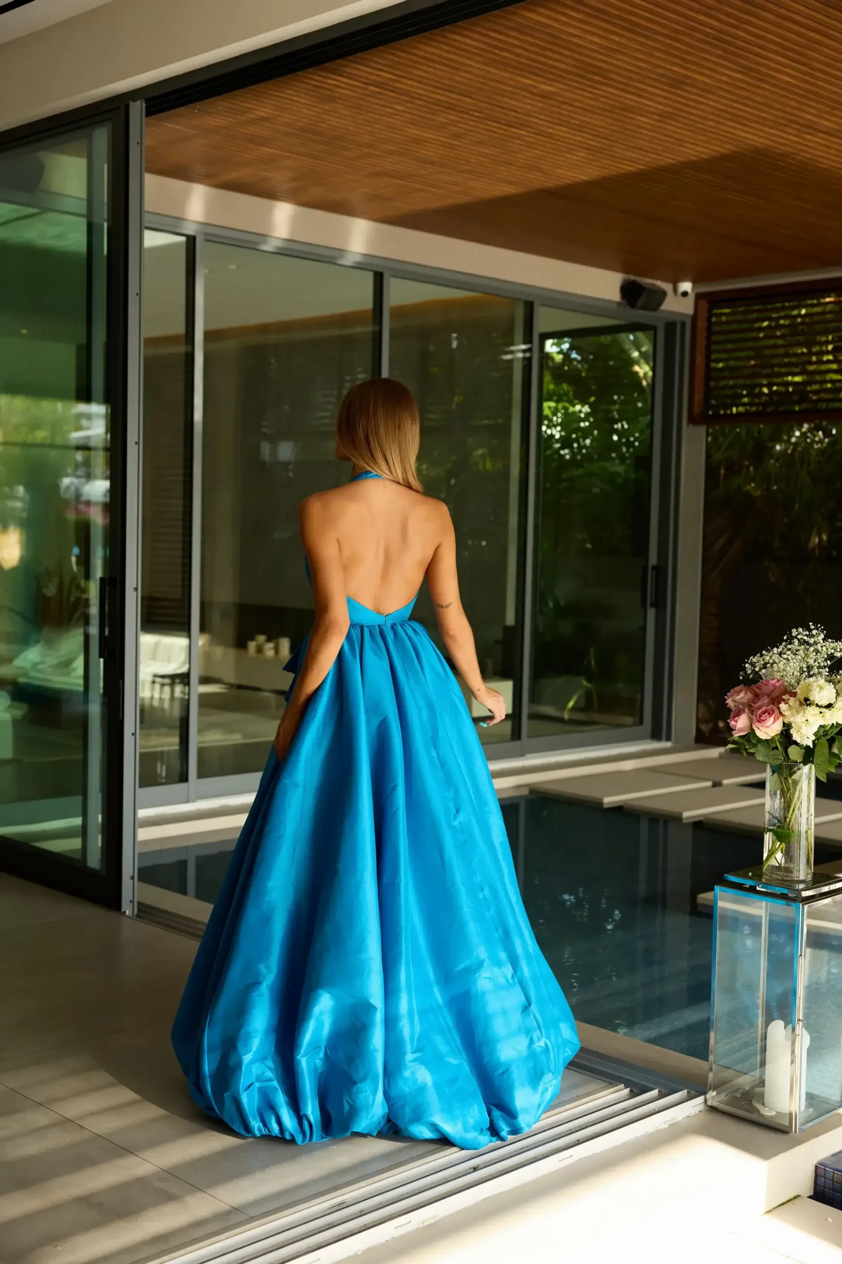 Model is wearing a sleeveless halter blue ball gown for prom 2026