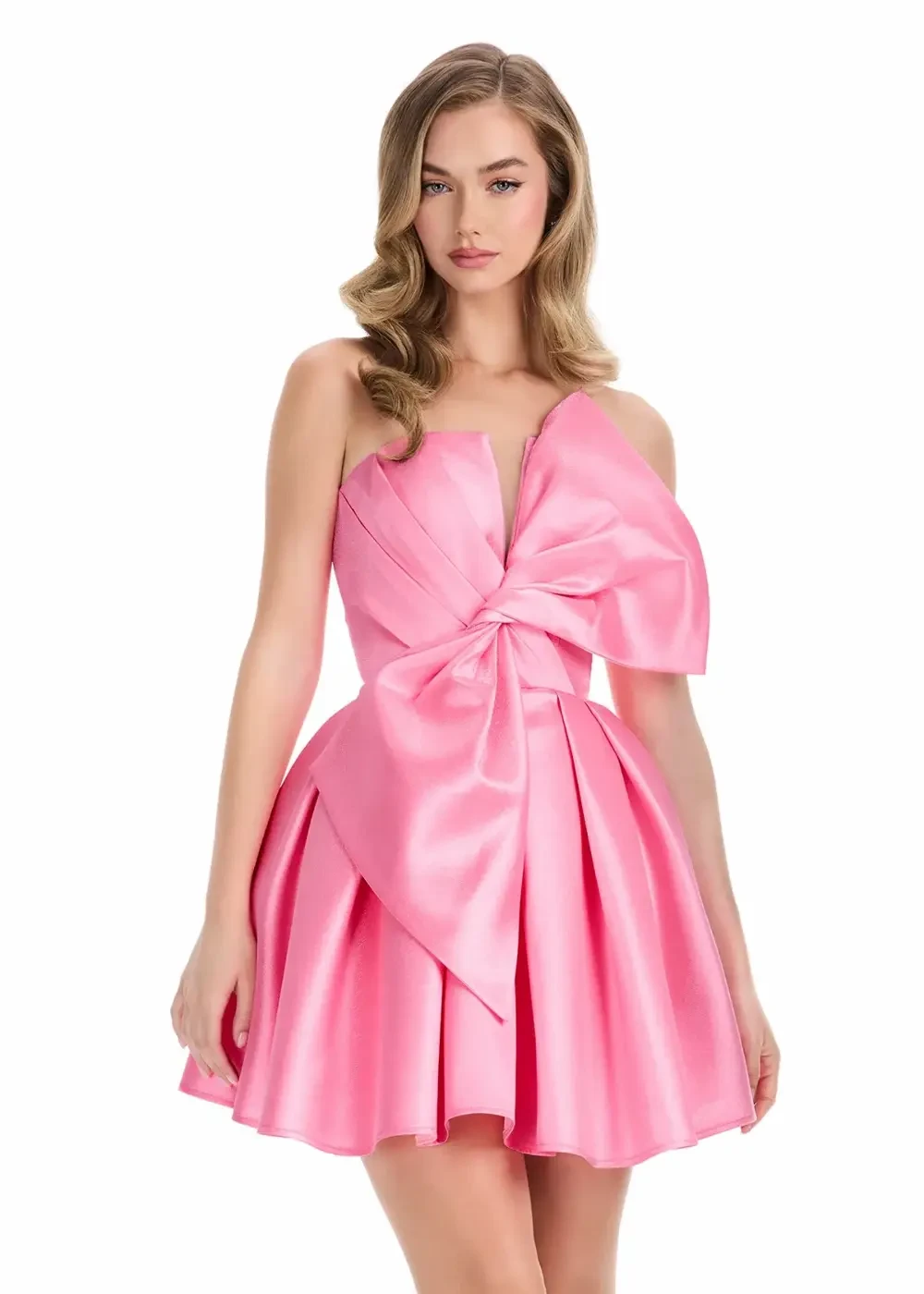 A young woman wearing a pink satin dress with a large bow detail on the bodice and a flared skirt.