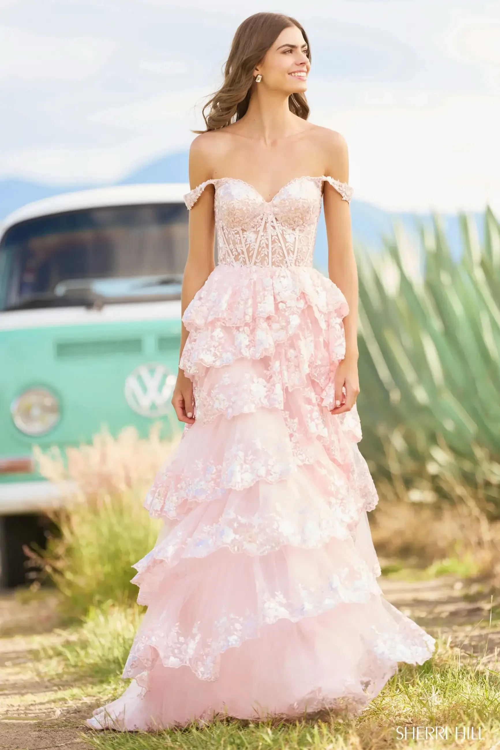 model is wearing a light pink off the shoulder tulle layered evening gown