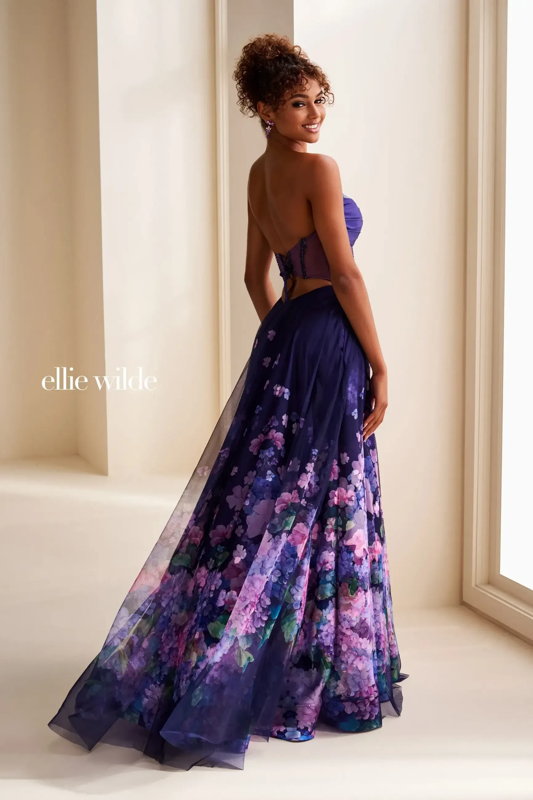 model is wearing a strapless purple floral prom dress